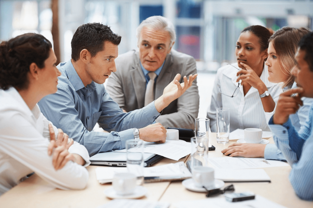 Collega's die met de leidinggevende discussie voeren over continu verbeteren