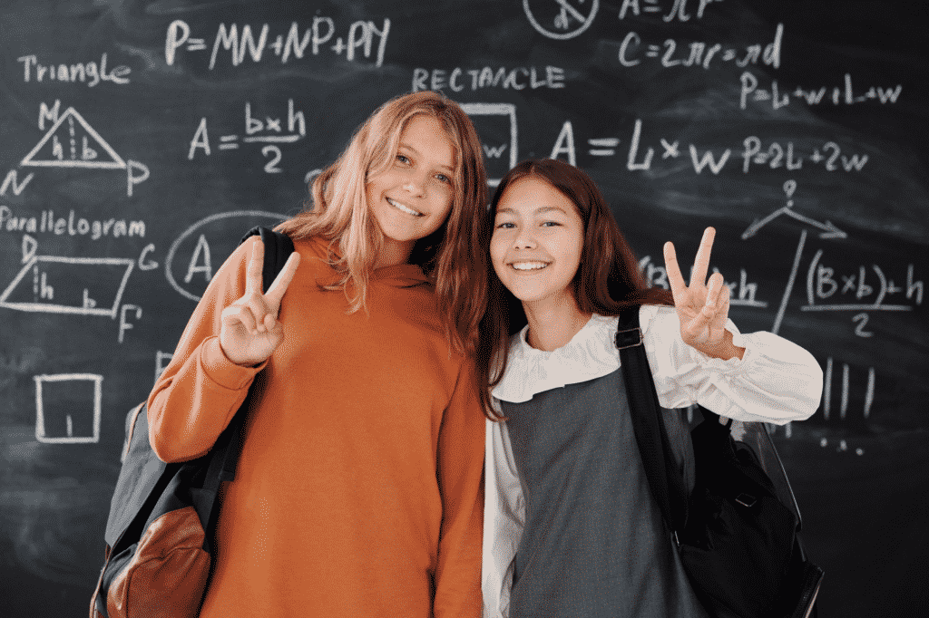 Foto van twee meisjes voor een schoolbord