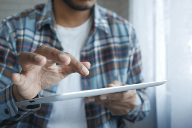 Foto van een man met blouse die AI tablet bedient