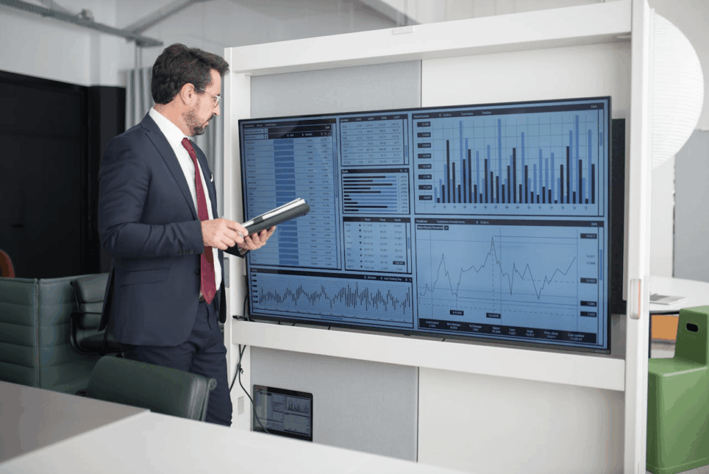 Zakenman analyseert data op een groot digitaal dashboard.