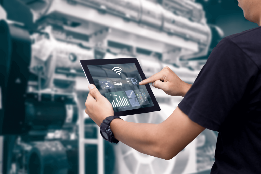 Foto van een persoon met een tablet die een installatie inspecteert